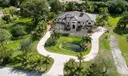 Impressive entrance with beautiful landscape, circular driveway and man-made pond