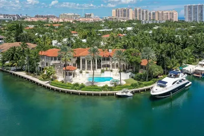 To the right of the house is a 98-foot yacht.  The