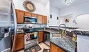 Open Kitchen with granite countertops, breakfast bar and stainless-steel appliances. Vaulted ceilings and tile flooring.
