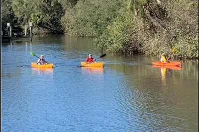 KAYAKERS PASSING NEARBY ON RIVER