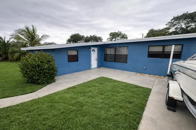 Blue house with lush lawn and walkway