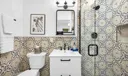 Primary suite bathroom- luxury newly updated shower, surrounded by modern patterned tile.
