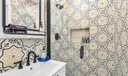 Primary suite bathroom- luxury newly updated shower, surrounded by modern patterned tile.